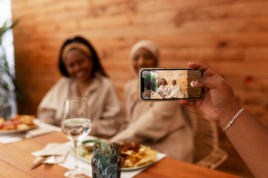 Young woman taking a picture of her friends in a restaurant
