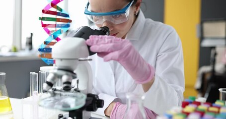 Scientist is holding tube and working with microscope in laboratory closeup - Powered by Adobe