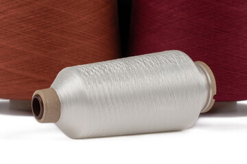 Spool of sewing thread, isolated on white background. Colored yarns used by factories in the clothing industry. Threads wound on the spool. Colored reels