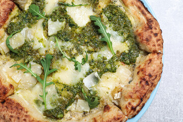 Delicious pizza with pesto, cheese and arugula on grey table, closeup
