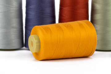 Spool of sewing thread, isolated on white background. Colored yarns used by factories in the clothing industry. Threads wound on the spool. Colored reels