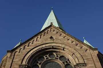 Upper front of Apostelkirche protestant church under a blue winter sky, concept of religion, Christ, holiness, resurrection and worship (horizontal), Kaiserslautern, Rhineland Palatinate, Germany