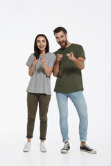 Fototapeta premium Young couple point with finger and look at camera