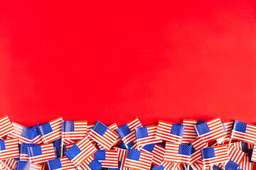 Fototapeta premium American flags flat lay on the red background with copy space. Happy Independence day USA.