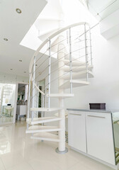 a white spiral staircase leading to a upstairs terrace inside a white themed home 