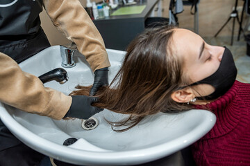 in salon the master in special gloves prepares the client for washing of the head
