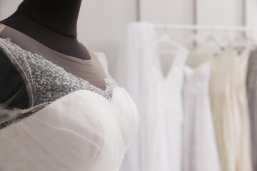 Mannequin with beautiful wedding dress in atelier, closeup. Space for text