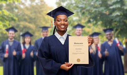 education, graduation and people concept - happy graduate student woman in mortarboard and bachelor gown showing diploma of university over group of people on background - obrazy, fototapety, plakaty