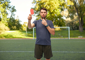sport, football and refereeing concept - male referee whistling whistle and showing red penalty...