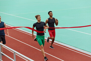 Obraz premium Sportsmen run on finish on treadmill on stadium