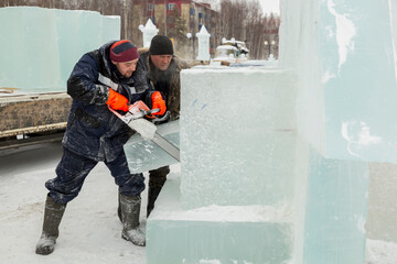 Fototapeta na wymiar Worker cuts ice panel with gasoline saw