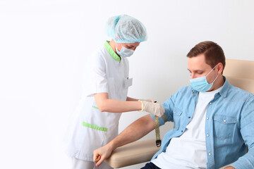 A man donates blood in a medical laboratory. A general blood test. Nurse and patient. The concept...
