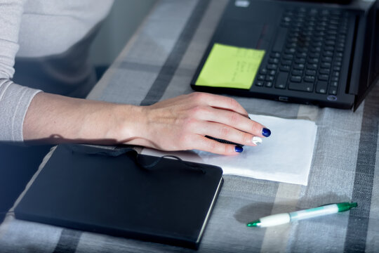 a woman's hand with painted fingernails, using the laptop computer with the wireless mouse in her home. selective focus