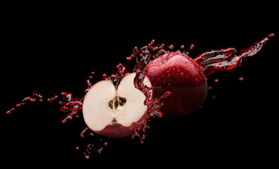 red apples in juice splash on a black background with clipping path