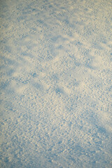 Texture of snow in sunlight. Snow lies outside. Cold weather.