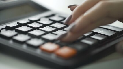 Close-up of a woman's hand using a calculator