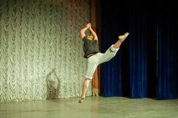 Ballerina jumps. Jump in dance. Dance teacher shows movement. Dance lesson on stage.