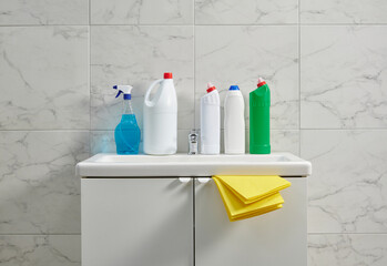 Cleaning kits on the cabinet sink in the bath room, yellow cloth, close up.