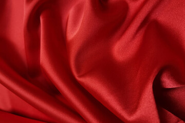 Naklejka na ściany i meble Red crumpled or wavy fabric texture background. Abstract linen cloth soft waves. Silk atlas or stretch jacquard. Smooth elegant luxury cloth texture. Concept for banner or advertisement.