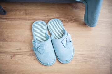 Slippers of female home turquoise color stand on the floor (top view)