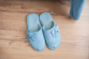 Slippers of female home turquoise color stand on the floor (top view)