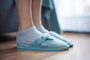 Women's legs in slippers of home turquoise (side view)