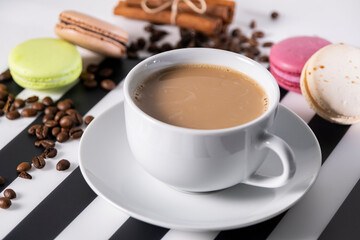 Cup of Fresh Morning Coffee with Milk and Colorful Macarons on Breakfast