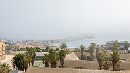 Pier in the fog, view of the tower of the Woermann House, Swakopmund, Namibia.