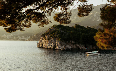 Beach in the sunset. Panorama of the sea with boat and mountains. Summer season