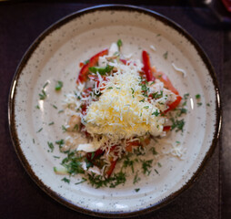 Fresh salad with chicken, vegetables and grated cheese on plate