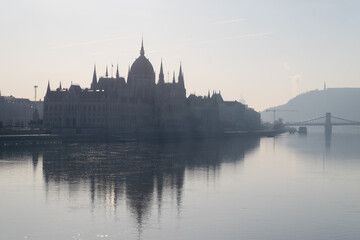 Fototapeta na wymiar Parliament building and Szechenyi chain bridge in morning haze in Budapest, Hungary