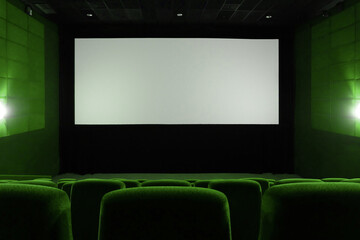 Empty green cinema hall. View on empty white cinema screen.