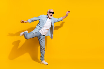 Full length body size view of attractive cheerful childish grey-haired man having fun isolated over...