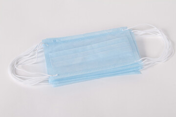 Blue disposable surgical face mask top view. Protective mask with ear straps against coronavirus and bacteria isolated on white background. Healthcare medical hygiene concept.