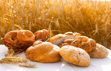 lot of different flavored bread, wheat, rye, on the table in the field outside