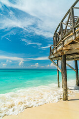 Beach and terrace on piles with a view on Indian ocean with boats, Zanzibar, Tanzania