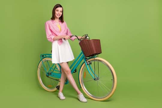 Full size photo of smiling beautiful girl traveling bicycle vehicle free time isolated on green color background
