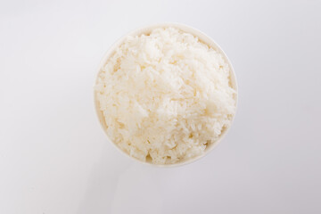 boiled rice on a white plate on a white background