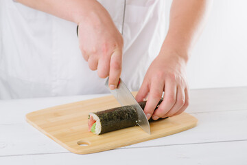 Fototapeta na wymiar the chef prepares sushi and cuts them with a knife