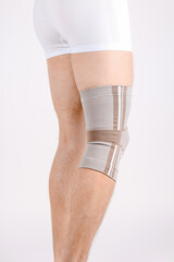 Knee Support Brace on leg isolated on white background. Elastic orthopedic orthosis. Anatomic...