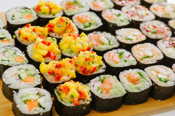Maki Sushi Rolls set on wooden board. Japanese traditional Cuisine. White background.