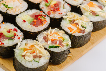 Maki Sushi Rolls set on wooden board. Japanese traditional Cuisine. White background.