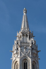 Fototapeta na wymiar Saint Matthias Church tower in gothic architecture with gargoyles against blue sky, Budapest, Hungary