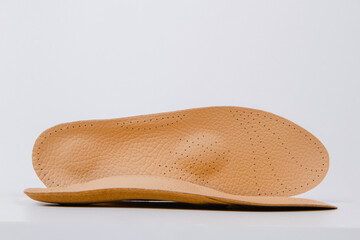 Isolated orthopedic insoles on a white background. Medical insoles. Foot care. Insole cutaway layers. Treatment and prevention of flat feet and foot diseases. Inner soles of shoes.