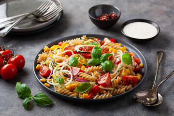 healthy pasta salad with zucchini sweet corn tomato and basil, vegetarian lunch
