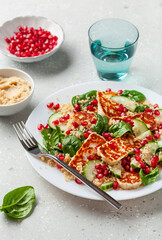 healthy halloumi cheese and couscous salad with cucumber spinach pomegranate hummus