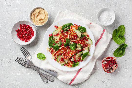 healthy halloumi cheese and couscous salad with cucumber spinach pomegranate hummus
