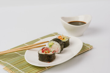 Maki Sushi Rolls set on wooden board. Japanese traditional Cuisine. White background.