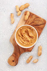 smooth peanut butter in bowl on gray background
