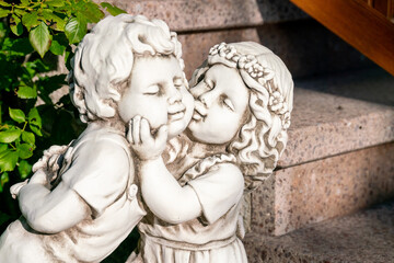Monument to a girl kissing a boy on the cheek. A statue of white stone